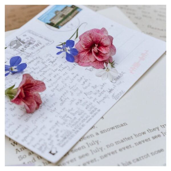 A postcard with writing and flowers on it