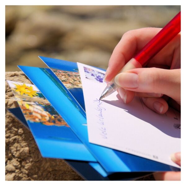 A person writing on a postcard